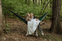 bride and groom cuddling in a hammock in their elopement attire