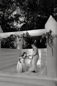 Bride and groom frolic on bouncy house