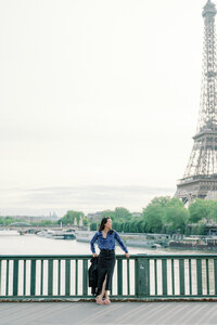 Kim-Trang stands outside of the Eiffel Tower waterfront
