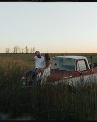 cozy couple laying on a blanket with intertwined hands captured during a Kansas lifestyle session

