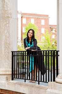 Girl leaning against the banister wearing her gown and stole at Vanderbilt