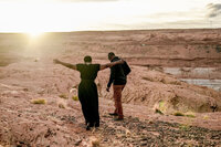 A couple engaged with the expansive desert landscape of Lake Powell in the background, capturing the essence of adventure and romance.