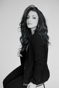 Black and white headshot of Amy of promise bridal artistry siting on a chair siting to the side with a smize.