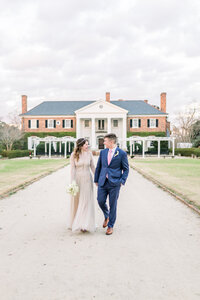 Newlywed bride and groom walk down path at Old Wide Awake Plantation in South Carolina by Karen Schanely