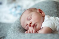 A newborn baby sleeps peacefully.