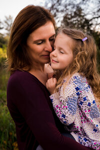Mom and daughter hugging with eyes closed and smiling