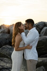 Happy couple celebrates their engagement at Jetty Park Beach in Port Canaveral as she proudly shows her ring, photographed by an Orlando Proposal Photographer.