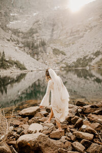 bride walking on rocks by the ocean