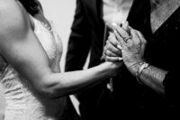 A bride and grandmother holding hands.