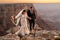 A couple sharing a private, intimate elopement ceremony at the Grand Canyon’s scenic viewpoint, surrounded by nature.