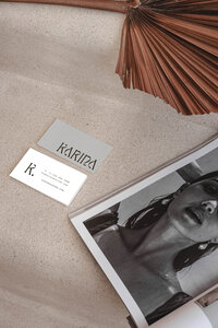 Karina wellness Canva brand kit mockup featuring minimalist business cards for wellness coaches styled with a neutral magazine layout and dried palm leaf accent.