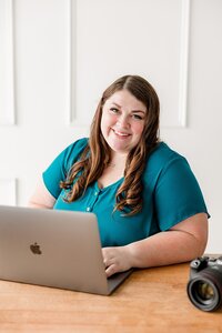 Headshot of Emily sitting at her desk editing photos.