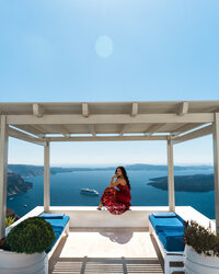 Isabella in a red dress on a terrace in Greece
