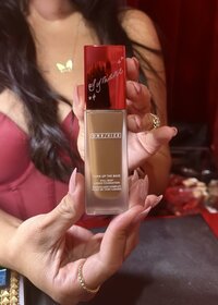 Cat Lauren Calligraphy holding a bottle of foundation hand-engraved for  guests at the One/Size launch party