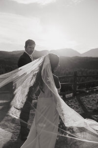 Bride and groom walking at sunset with a flowing veil and mountain backdrop, captured by a Washington wedding photographer.