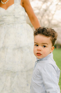 A little boy holds his mama's hand in the Bloesempark. 