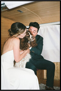 A couple in wedding attire with their dog