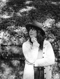 Eugene web designer Carrie of Bloem Creations has one hand on her chin and looks off to the side. 