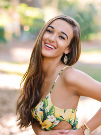 High school senior girl laughing in yellow floral top during outdoor portrait session in Charleston, SC
