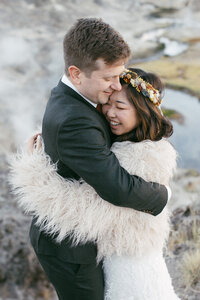 A bride and groom kiss at sunset while atop Taft Point at Yosemite National Park. 