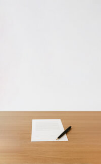 A paper and pen rests on a table, representing modifications mediation.