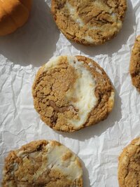 pumpkin cheesecake cookie on white parchment