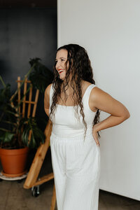 Taysha smiling looking to the left of the camera wearing an all white outfit.