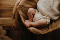 Baby feet in a basket at a boho photography studio in Fort Worth, Texas