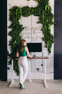 woman-wearing-green-shirt--standing-at-a-desk