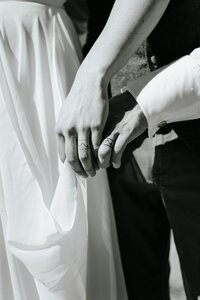 A close up of two people's ring fingers with rings tattooed on them.