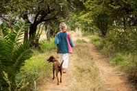 Sasha taking a walk with dog following on road at the farm in Chicago