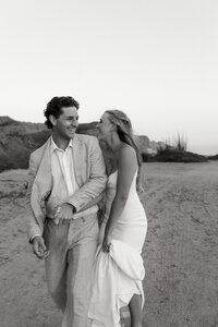 bride and groom laughing on the beach