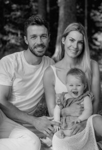 Family photoshoot shows happy parents with their radiant baby daughter.