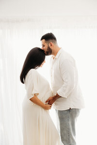 Roshni and her husband posing during their maternity portrait shoot with michelle kelly
