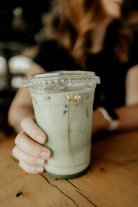 Closeup of Chanae holding an iced matcha.