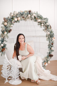 woman sitting in a cozy christmas egg chair decoration by miami christmas mini session photographer msp