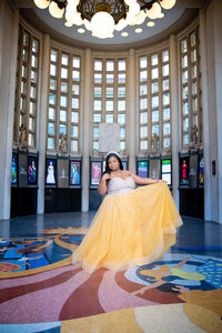 Arissa in yellow princess dress framed under the chandelier at the St. Louis Muny