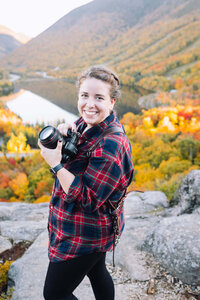 Photographer holding camera on top of Artist Bluff Trail in New Hampshire
