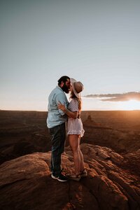 Couple kissing near a cliff in Utah.