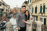 A couple kisses under Rialto bridge in Venice, Italy