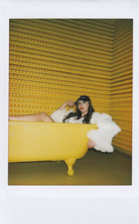 Polaroid of Sasha in a yellow bathtub