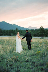 bride and groom walking together at sunset in Colorado