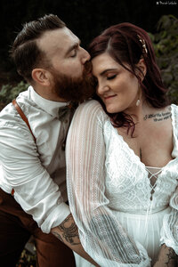 groom kissing brides forehead