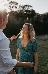 husband fixes wifes hair at their couples maternity session