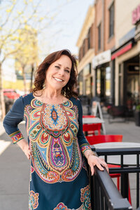 Woman in colourful dress standing outside in downtown Kelowna for urban brand photoshoot.