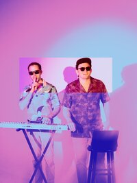 Musicians performing in front of vibrant purple and pink lights with synth equipment – bold music branding session by Mewphotovideo