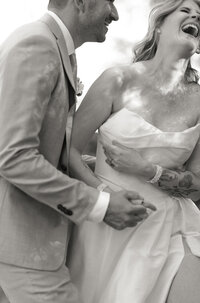 bride and groom holding each other and laughing