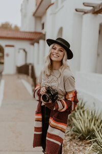 Kylee holding her camera and smiling at the camera