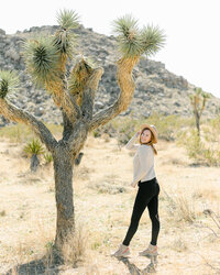 Emily Brianne at Joshua Tree National Park standing next to a. tree