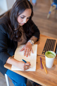 Stephanie, Founder of BCWise Consulting, writing in her notebook 